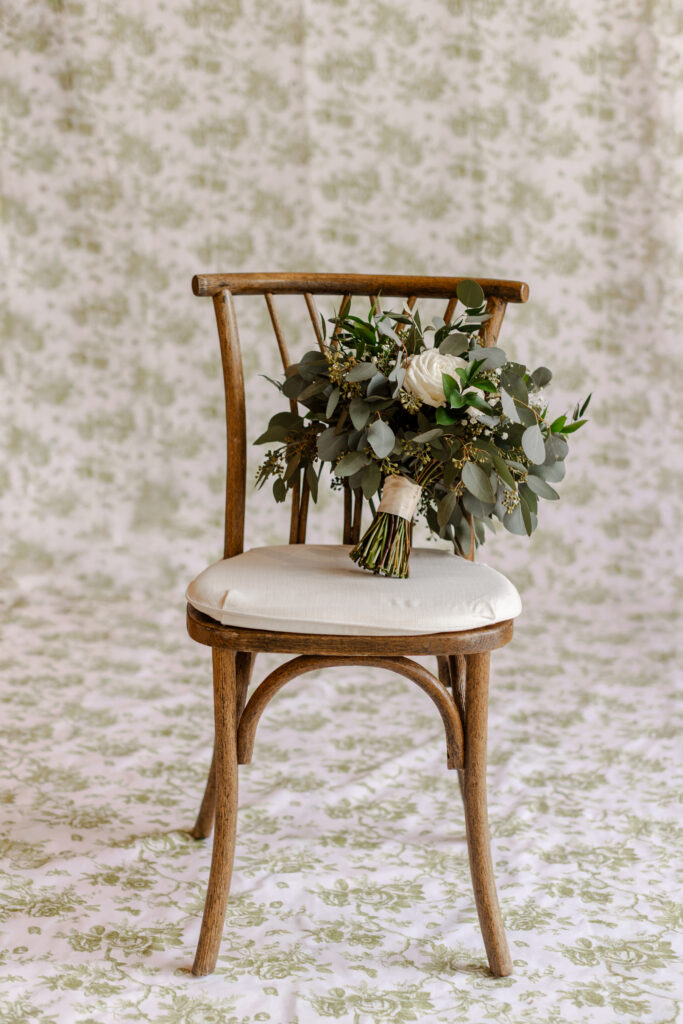 A soft bridal bouquet sits on a vintage chair in a quiet space, representing slow, intentional moments that remind you how to actually enjoy your wedding day. Captured in Greenville SC by Dani Lacey Photographs