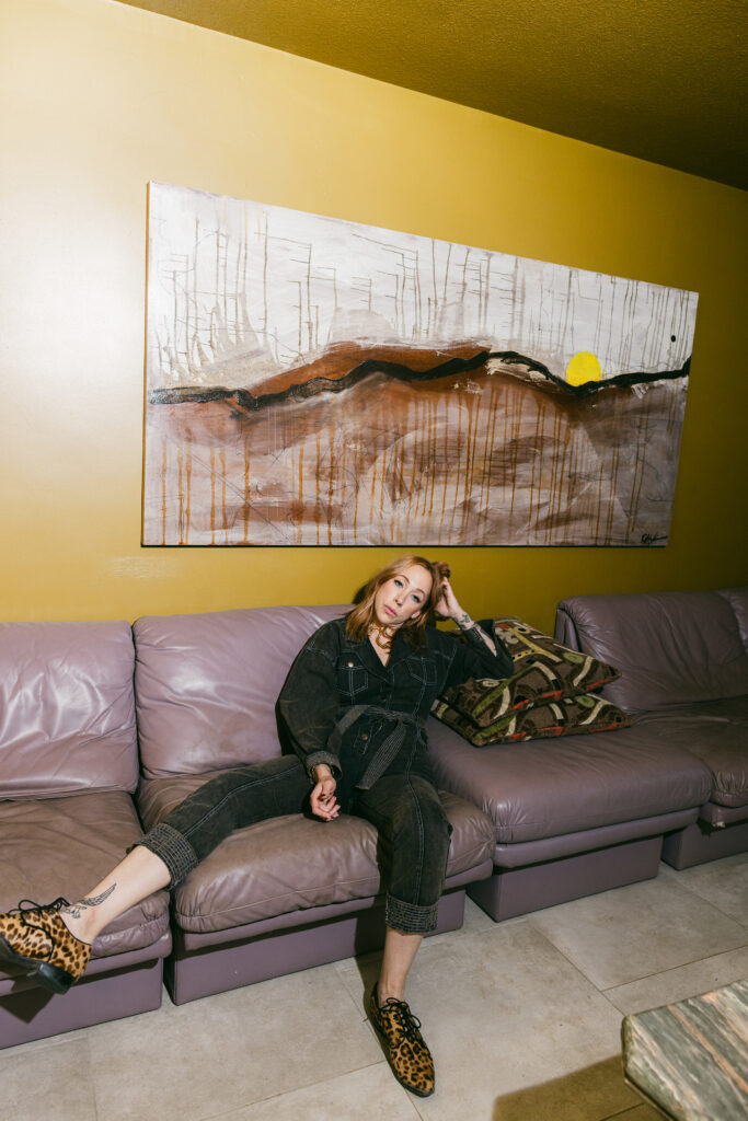 Woman lounging on a retro purple couch in a moody branding photo session, photographed in Greenville SC by Dani Lacey Photographs.