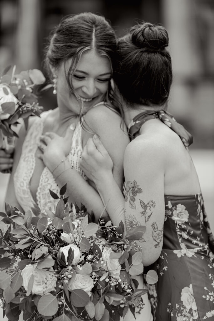 A bride and her bridesmaid sharing a heartfelt laugh, bouquet in hand Greenville, SC. Captured in editorial style by Dani Lacey Photographs.