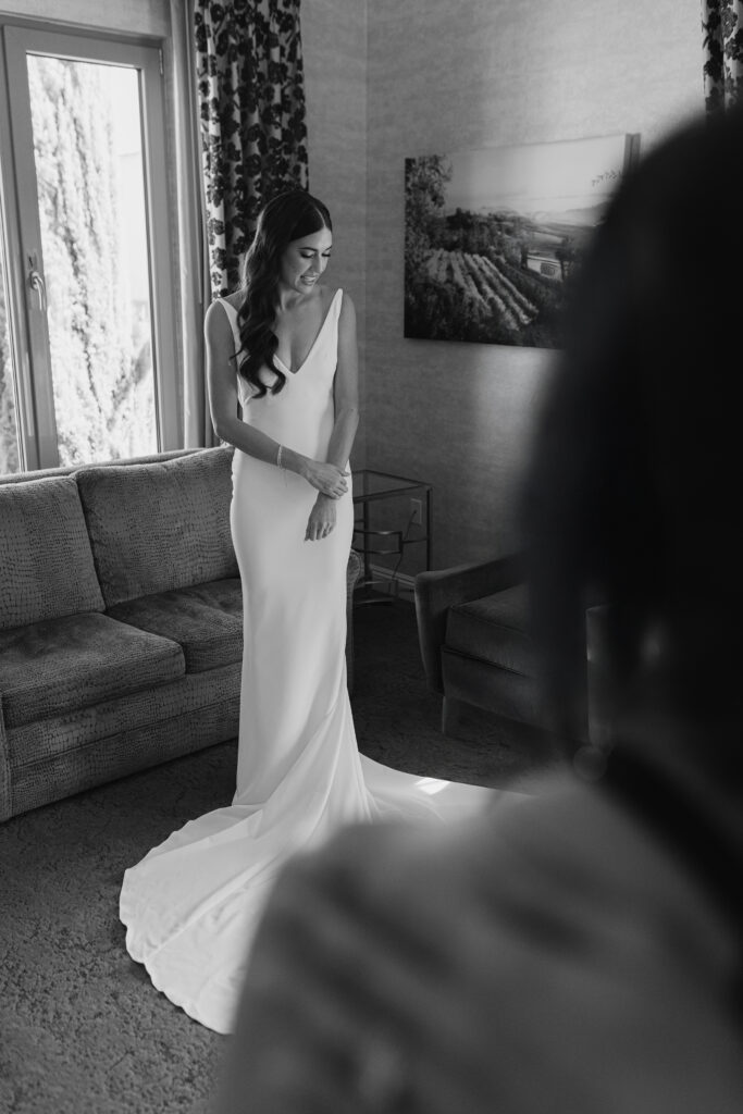 Bride standing in a softly lit room in a sleek white gown before her wedding, Greenville South Carolina — Dani Lacey Photographs