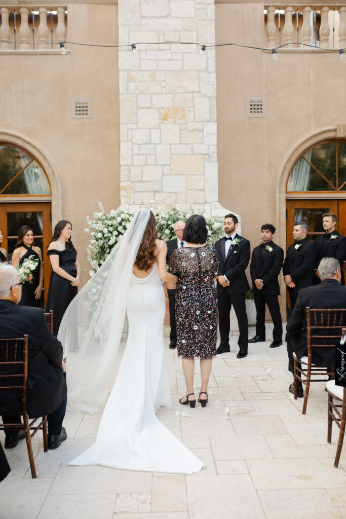 Bride walks down the aisle toward the groom during an elegant outdoor courtyard ceremony, Greenville South Carolina — Dani Lacey Photographs