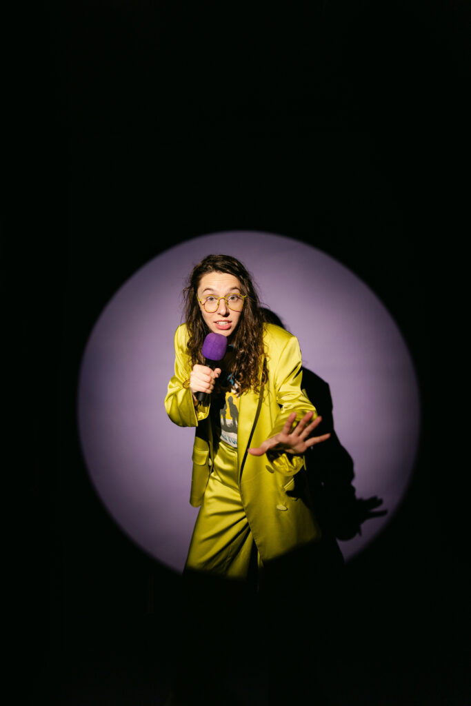 Greenville South Carolina branding photographer captures dynamic stage-style portrait with spotlight and purple mic, channeling SNL vibes—it’s time for a visual rebrand.