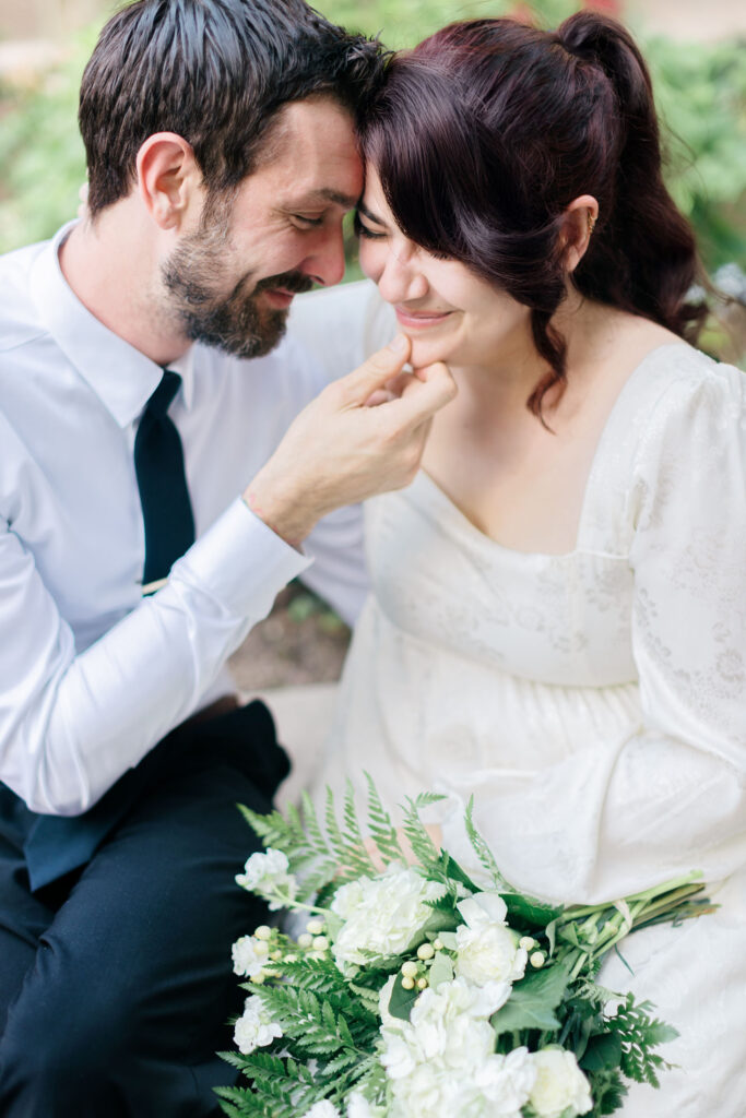 Close-up of groom gently holding his bride’s chin as they lean together with smiles during their downtown Spartanburg courthouse wedding. Captured by Greenville South Carolina wedding photographer Dani Lacey Photographs.