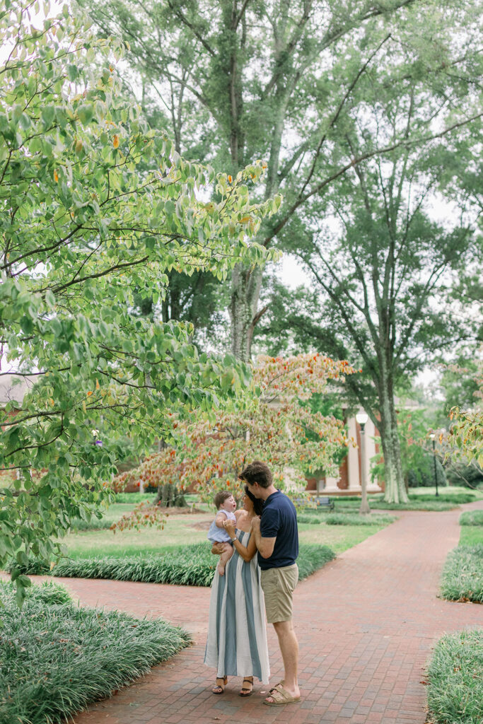 A family stands together under a tree canopy during Greenville SC Family Portraits at Furman University. Dani Lacey Photographs.