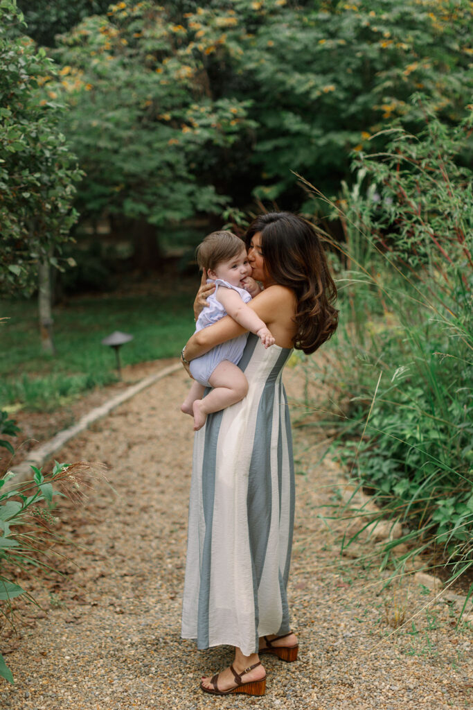 A mother lovingly kisses her baby during Greenville SC Family Portraits at Furman University. Dani Lacey Photographs.