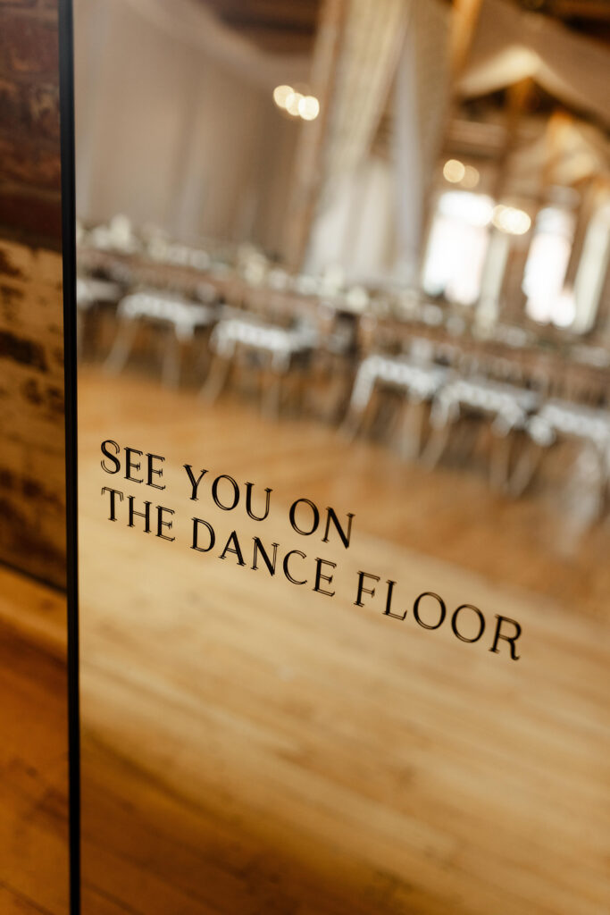 Mirror wedding sign at Judson Mill reading “See You on the Dance Floor,” a fun detail setting the tone for the reception. Dani Lacey Photographs.