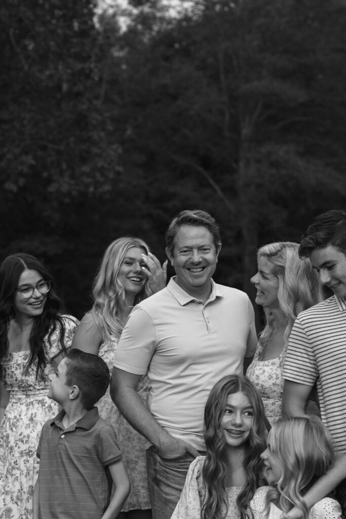 Black and white candid family portrait taken outdoors at their home in Greenville SC. Dani Lacey Photographs.
