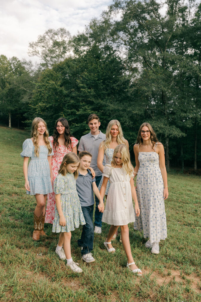 Siblings smiling together during an at-home family photo session in Greenville SC. Dani Lacey Photographs.
