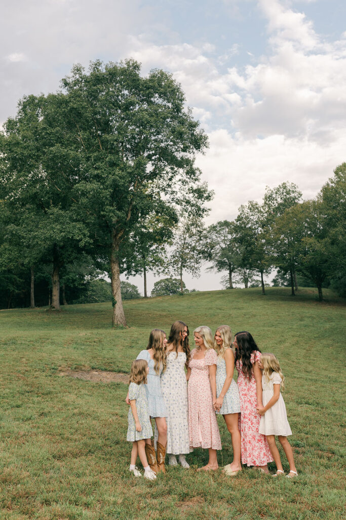 Family of women standing together in a field during a lifestyle photo session at their home in Greenville SC. Dani Lacey Photographs.