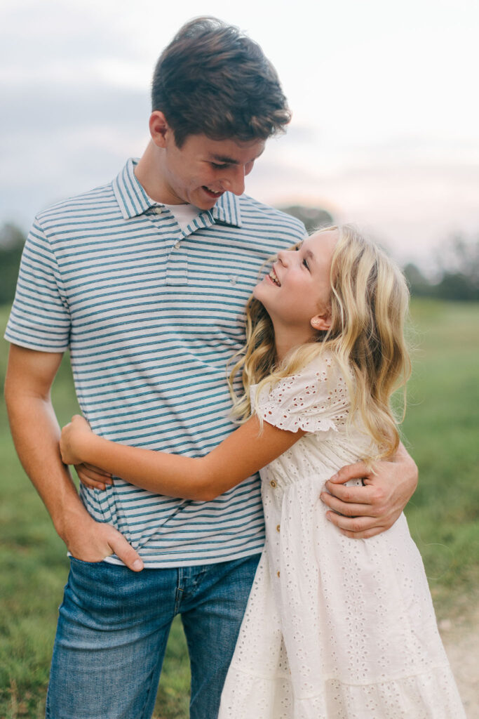 Brother and sister laughing and hugging during an at-home family photoshoot in Greenville SC. Dani Lacey Photographs.