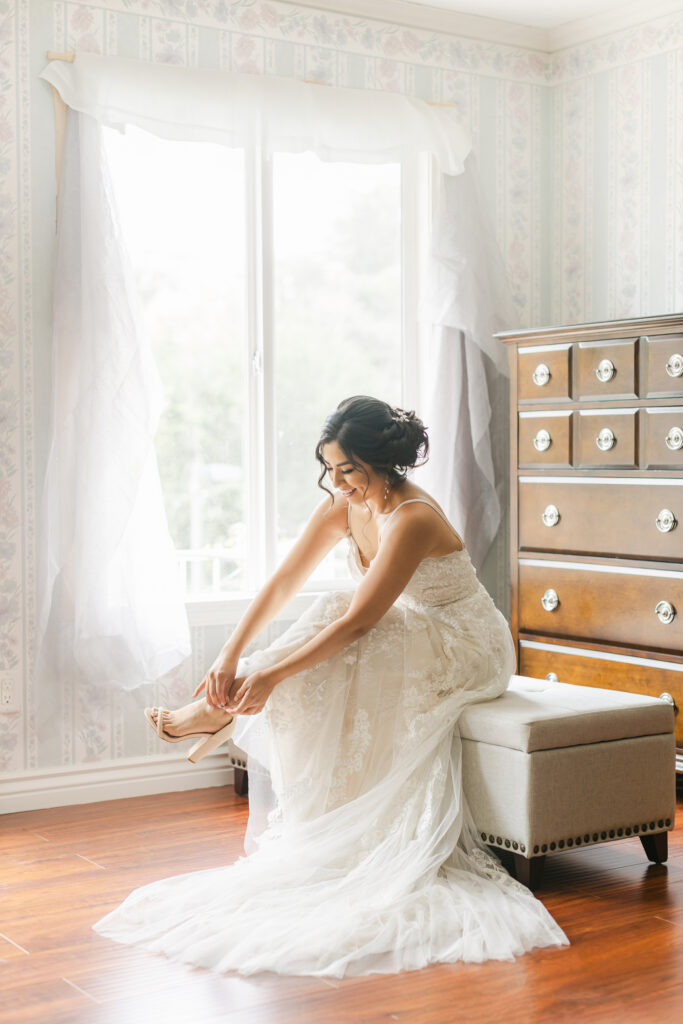 Bride putting on wedding shoes