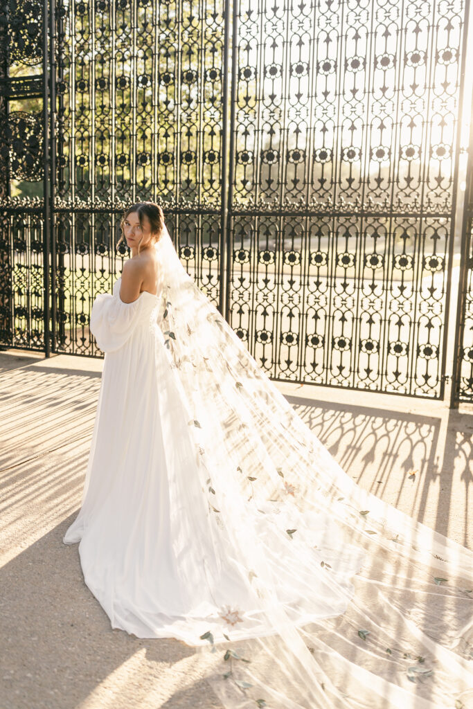 Bride standing at iron gates