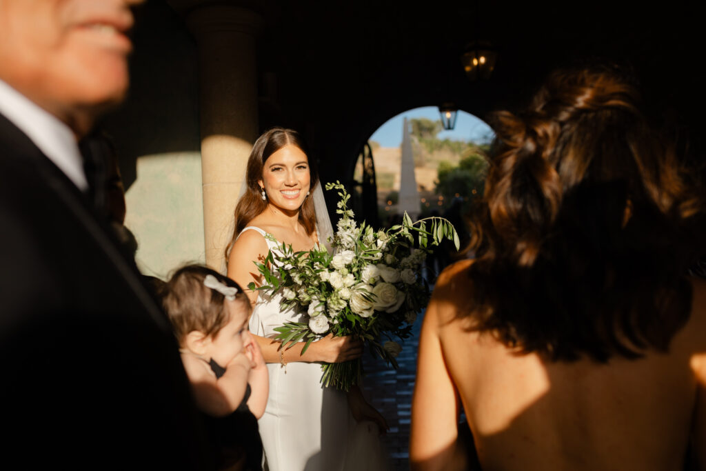 Bride standing in warm light holding a bouquet