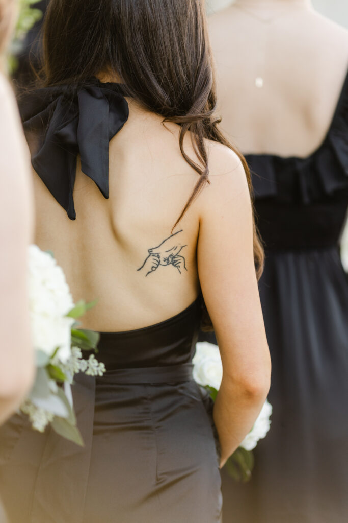 Bridesmaid wearing a black dress with a bow detail on the back during a South Carolina wedding.