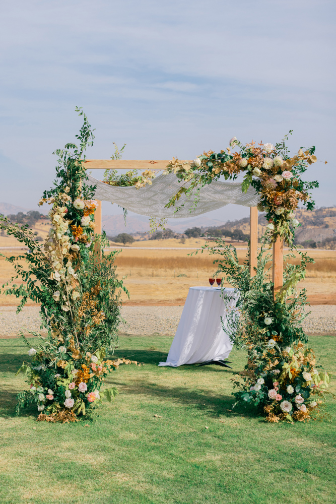 Outdoor wedding ceremony arch with florals