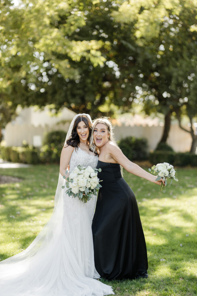 Bride and bridesmaid laughing together during a wedding day in South Carolina, surrounded by soft natural light.
