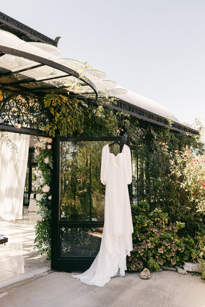 Wedding dress hanging on glass door