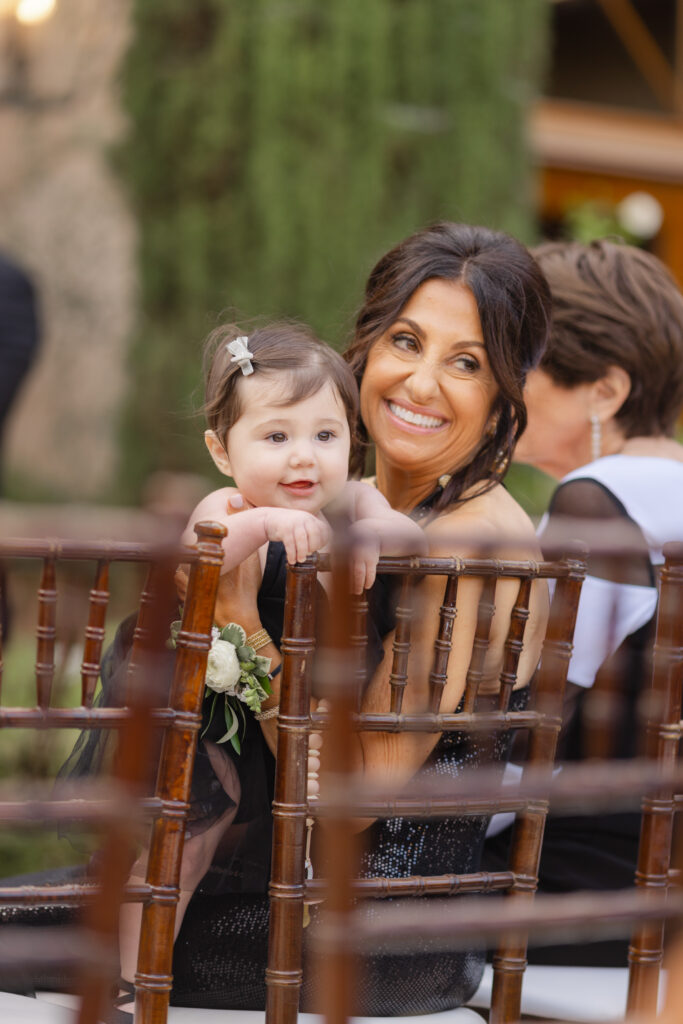 Wedding guest holding a baby during an outdoor ceremony in South Carolina.