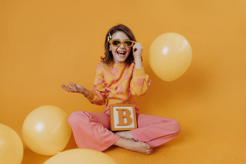 Child laughing with yellow balloons in studio Dani Lacey Photographers The Hidden Cost of Being Too Flexible as a Photographer