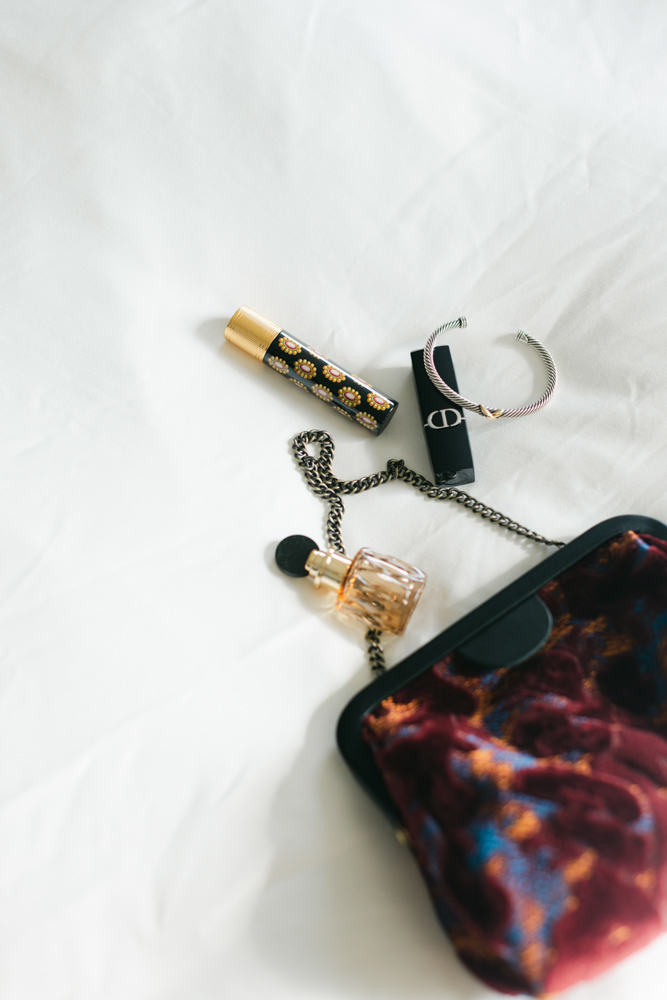 Bride accessories and perfume on white sheet