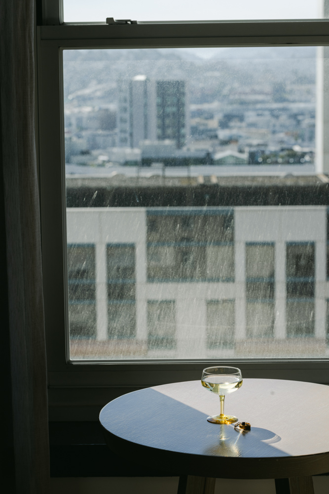 Champagne glass and ring by window