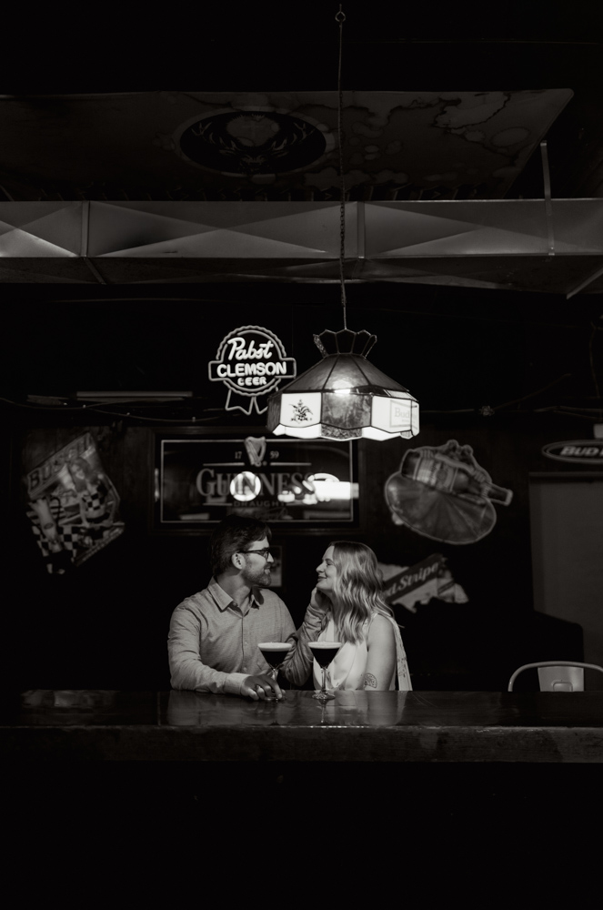 Couple sitting at bar during Clemson engagement session