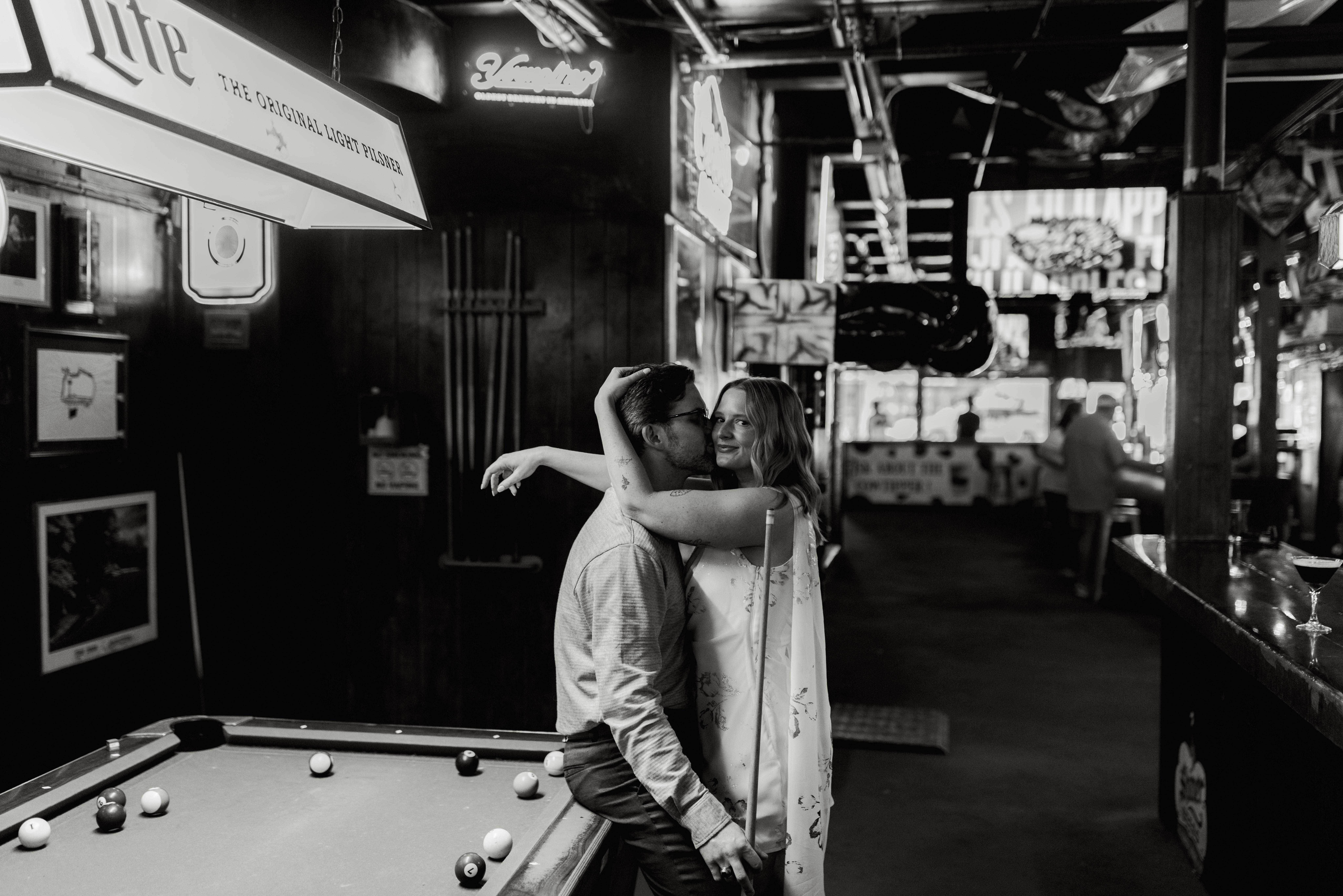 Couple embracing beside pool table inside Clemson bar