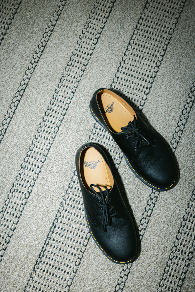 Black Doc Martens shoes on patterned rug