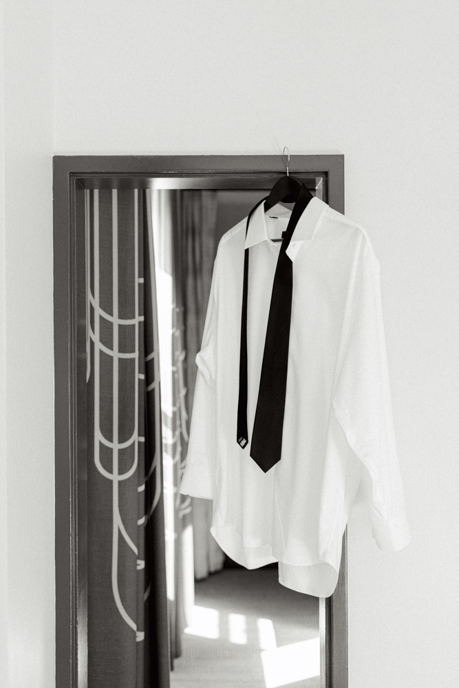 Groom shirt and tie hanging on mirror