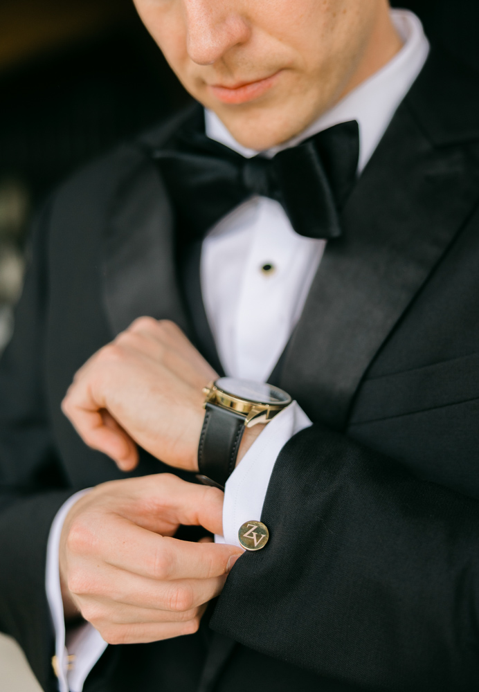 Groom adjusting cufflinks before wedding ceremony