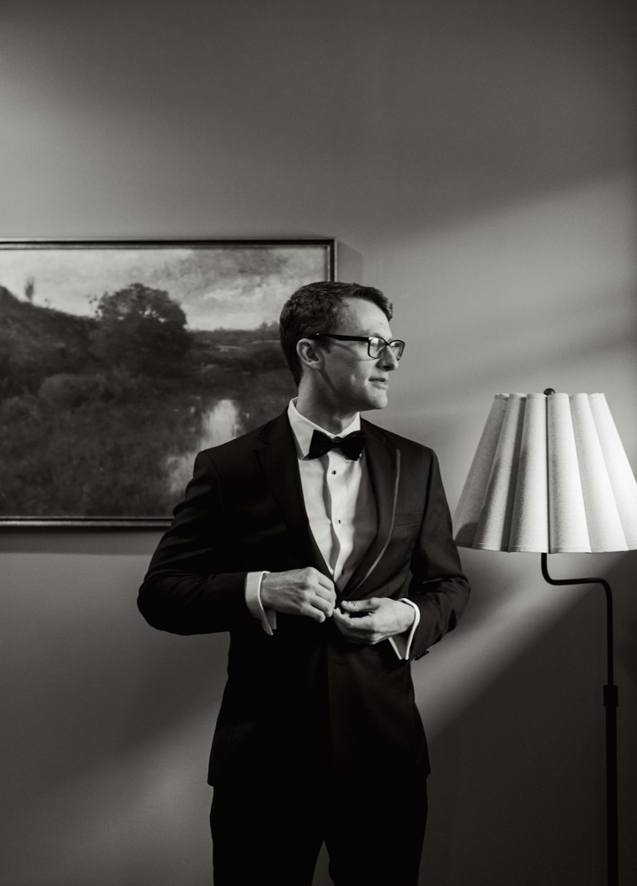 Groom adjusting tuxedo jacket