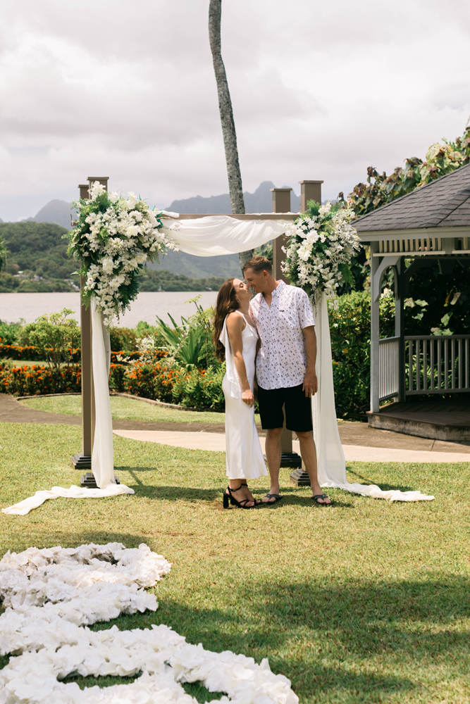Couple beneath floral ceremony arch at Aloha Ke Akua