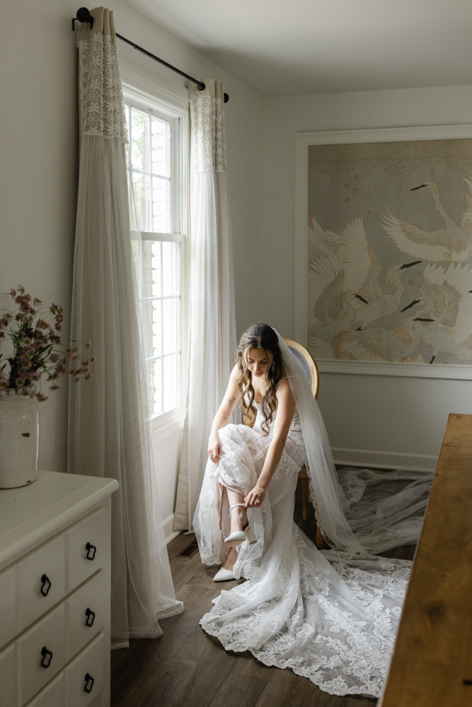 Bride putting on her wedding shoes in the bridal suite