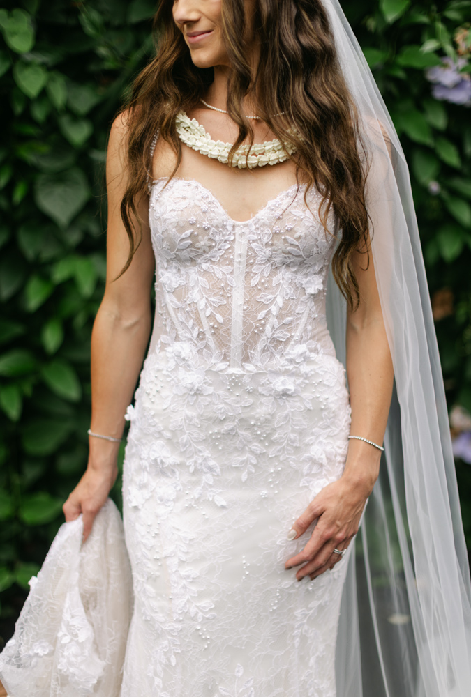 Close-up of bride's wedding dress and lei