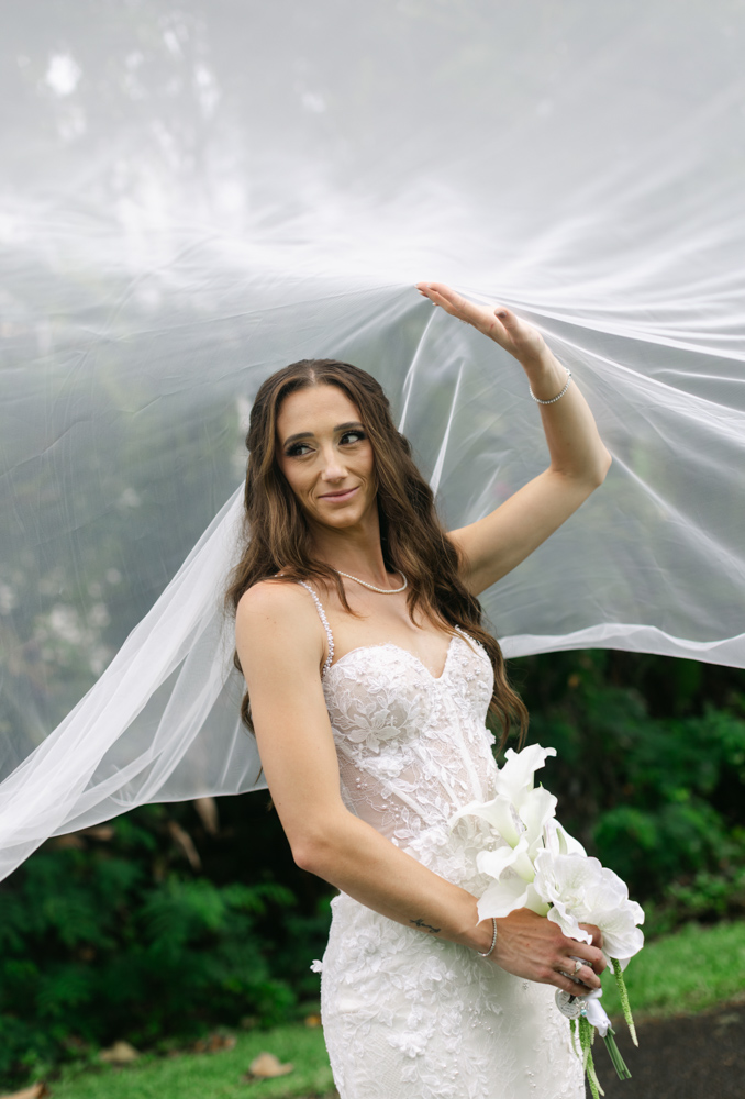 Bride holding flowing veil during portrait