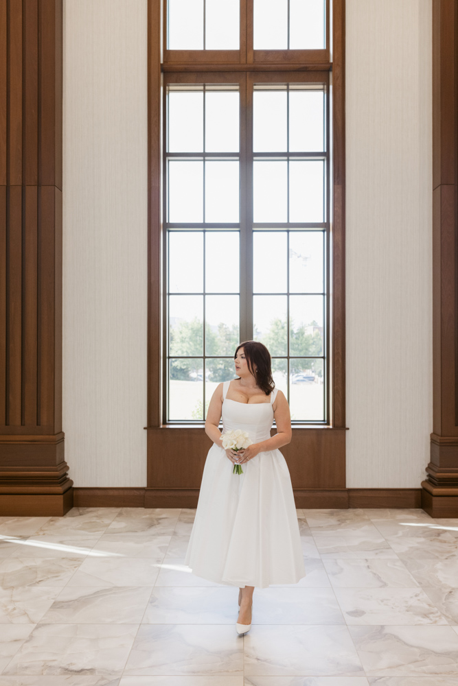 Bride standing beneath tall courthouse windows