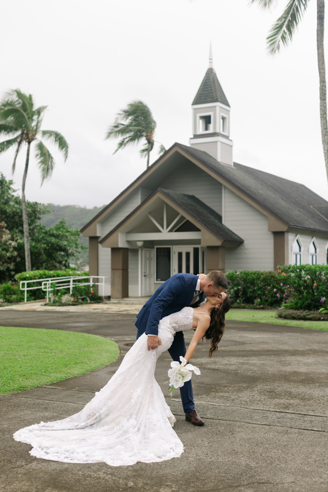 Bride and groom dip kiss outside chapel