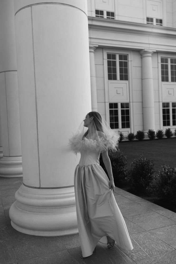 Bride posing beside large courthouse column