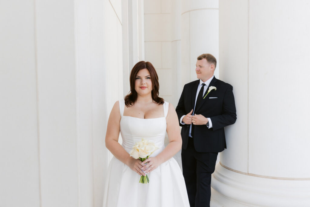 Bride and groom portrait beside courthouse columns
