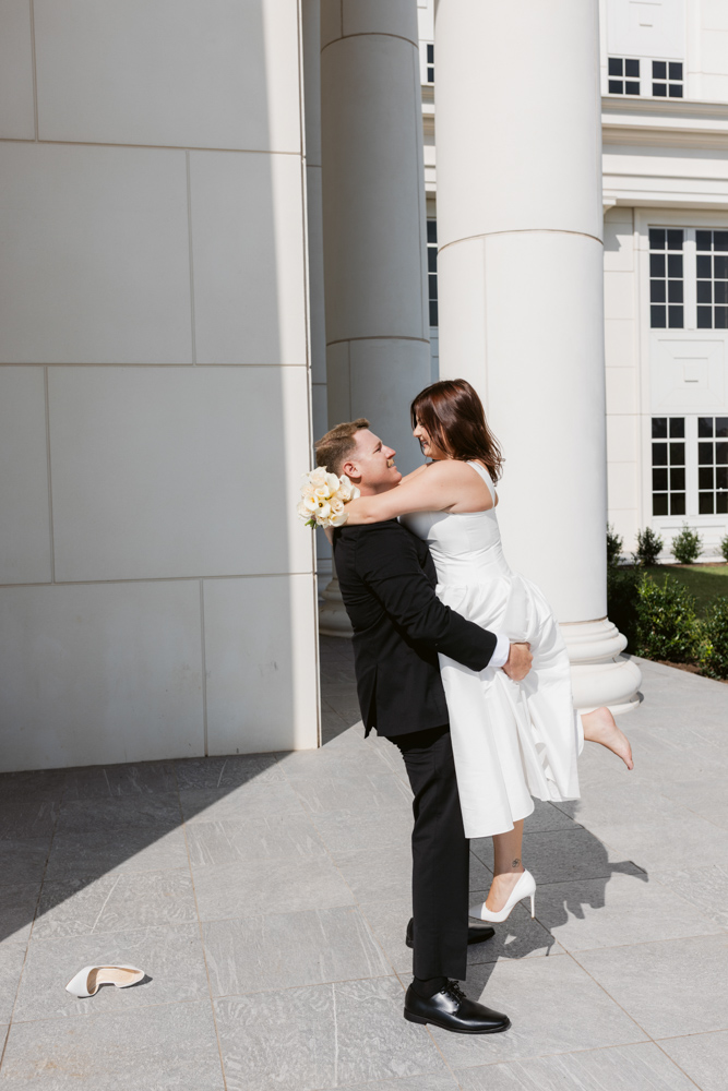 Groom lifting bride outside the Spartanburg County Courthouse