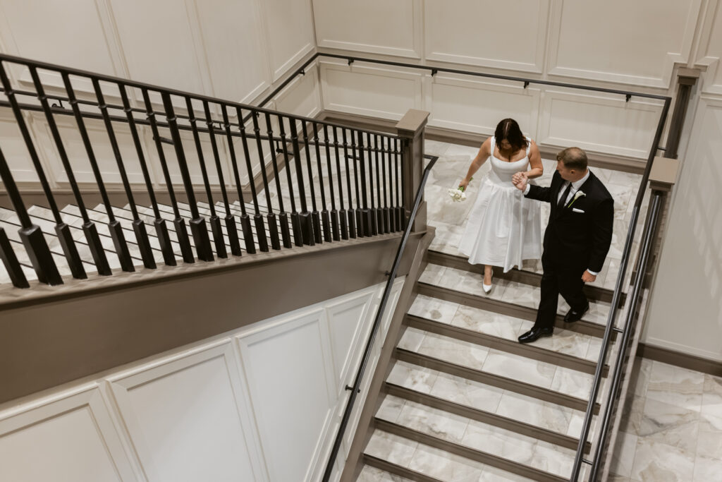 Bride and groom walking down courthouse staircase