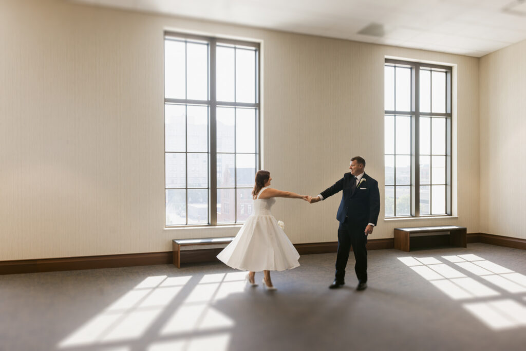 Bride twirling with groom inside the Spartanburg County Courthouse