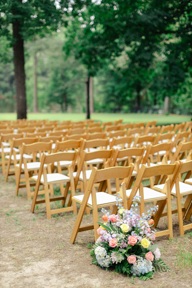 Outdoor ceremony chairs with floral arrangements