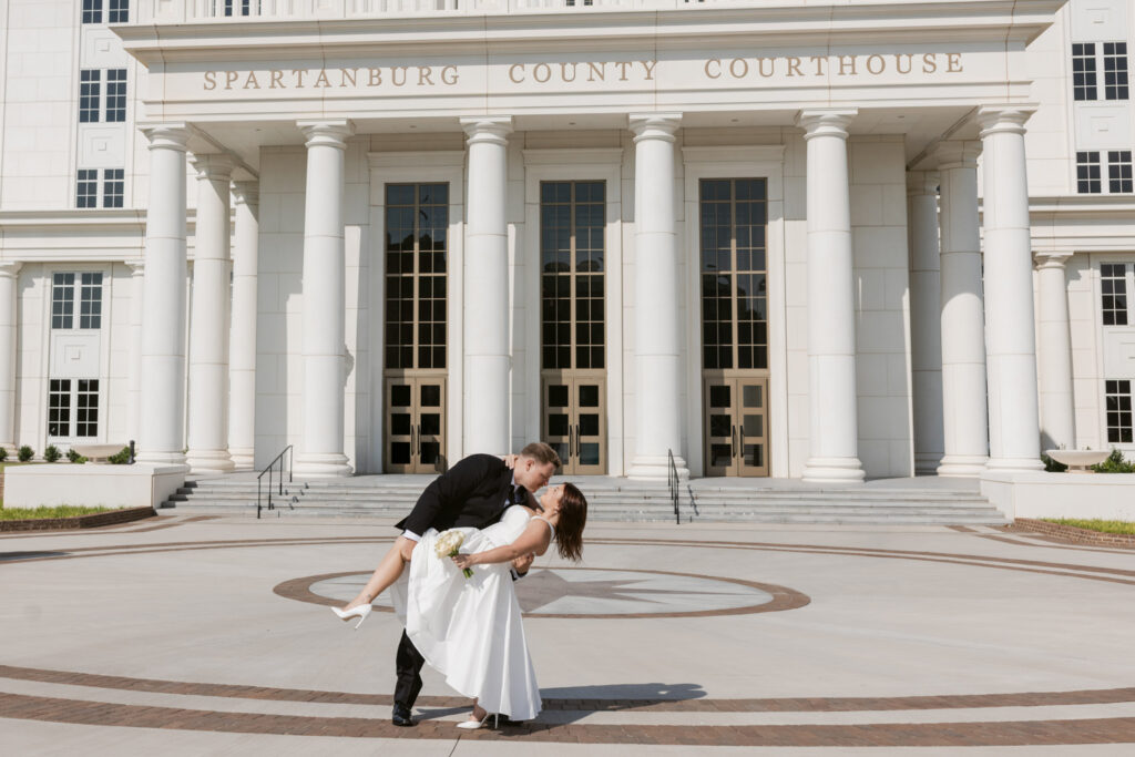 Bride and groom in front of Spartanburg County Courthouse