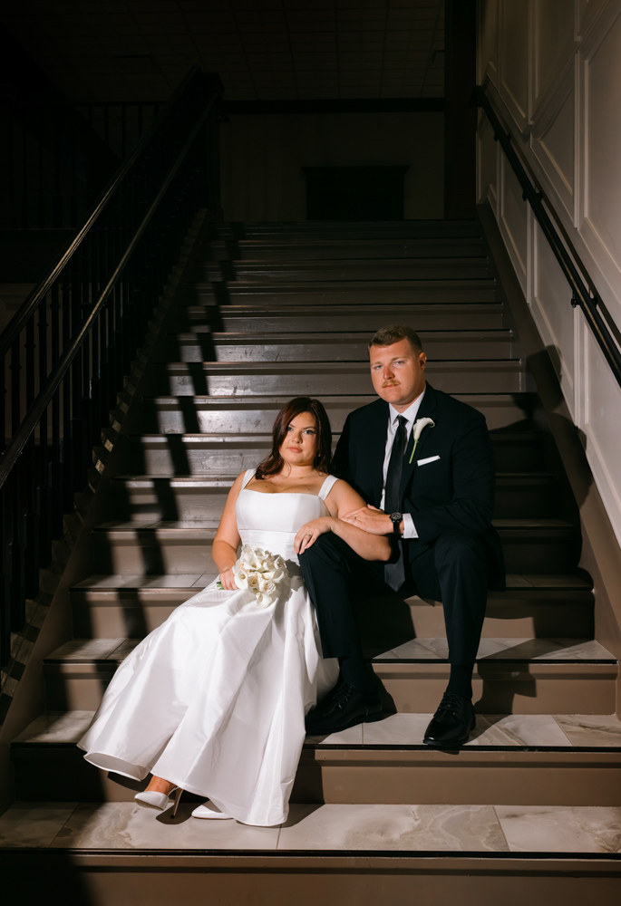 Bride and groom seated on courthouse staircase