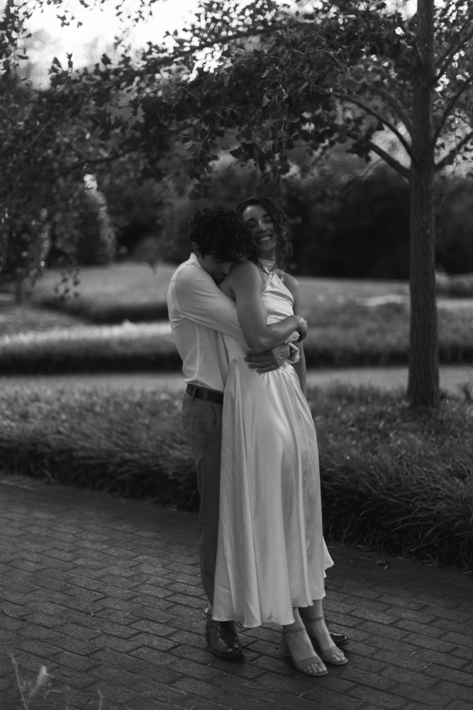Couple embracing beneath trees at Furman University