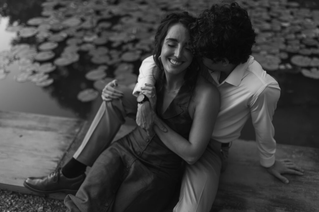 Couple cuddling beside Furman lily pond