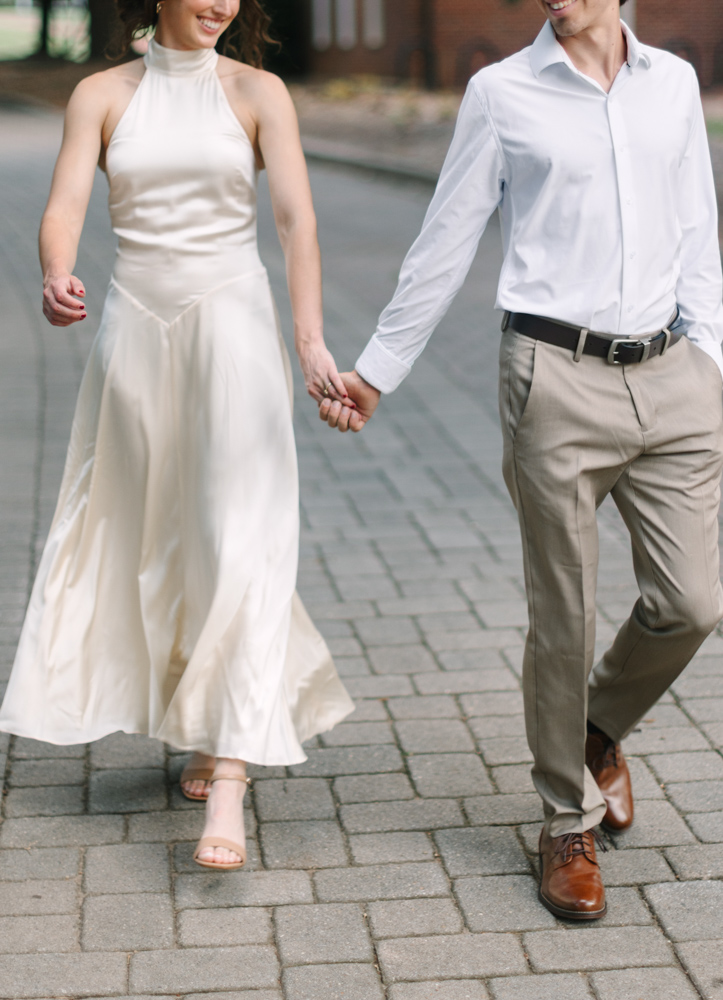 Engaged couple walking hand in hand at Furman