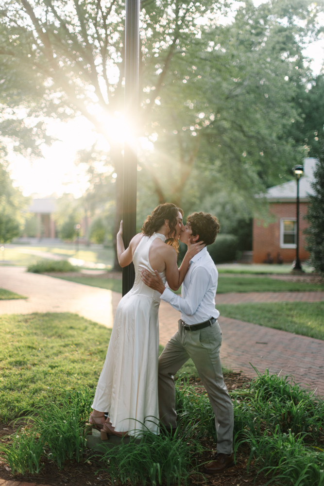 Engaged couple kissing during golden hour at Furman
