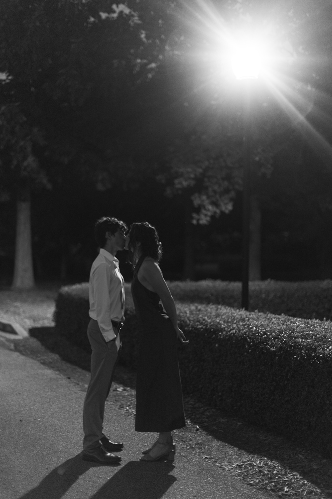 Black and white kissing couple at engagement session in South Carolina college campus.